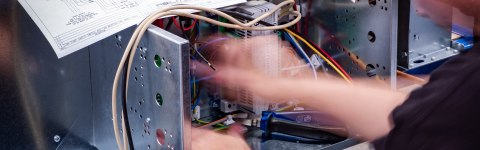 Blurry image of hand setting wiring in fan coil unit